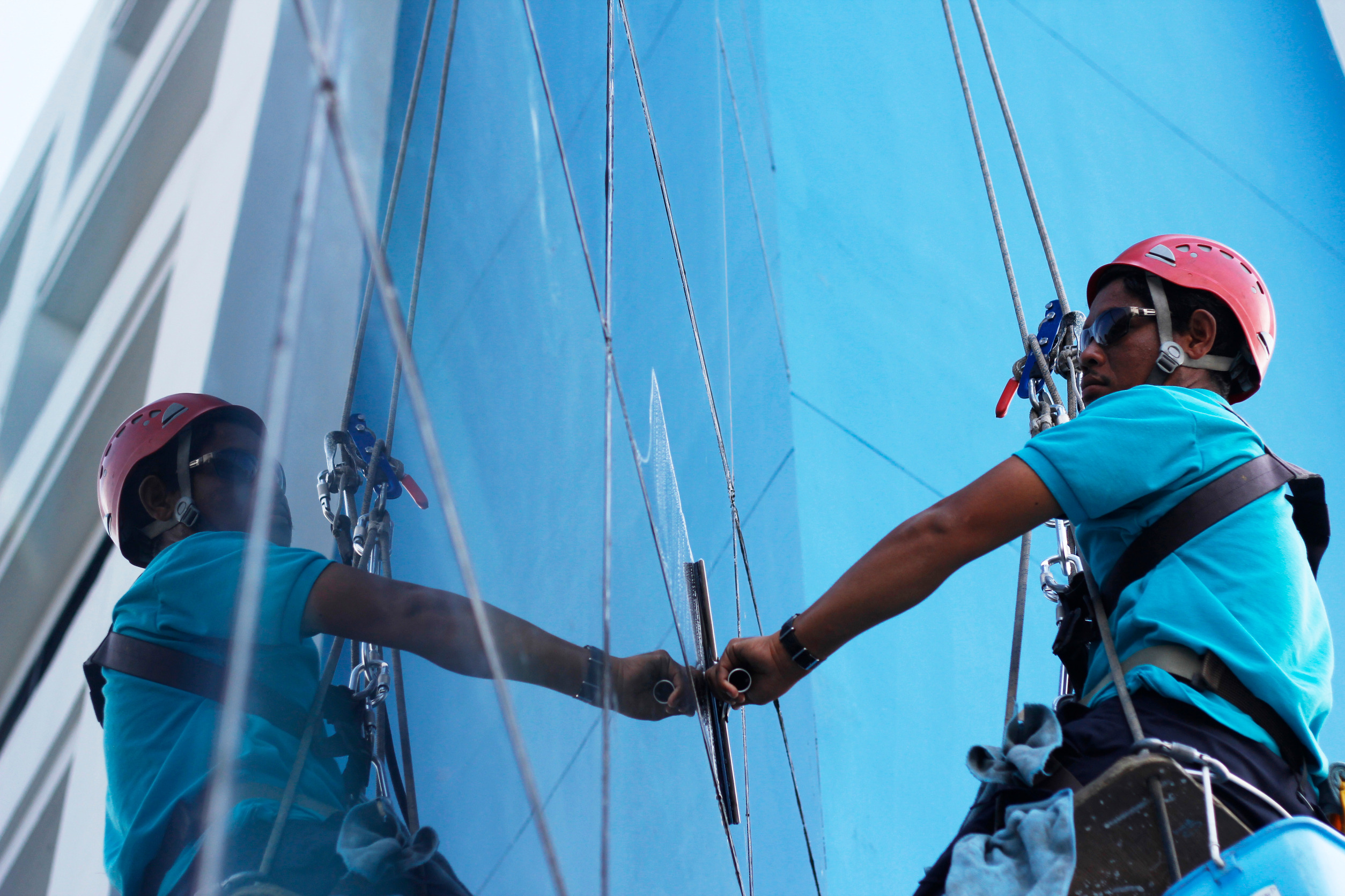 A man cleaning the windows of a commercial building.